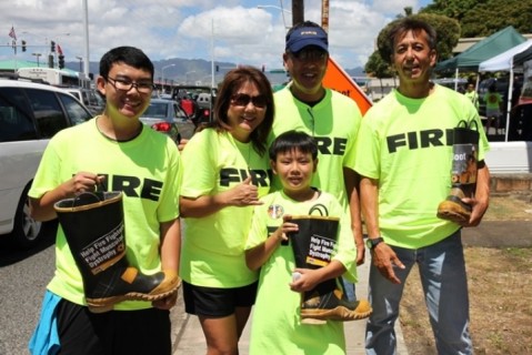 Fire Fighters stand with boots in hand for MDA